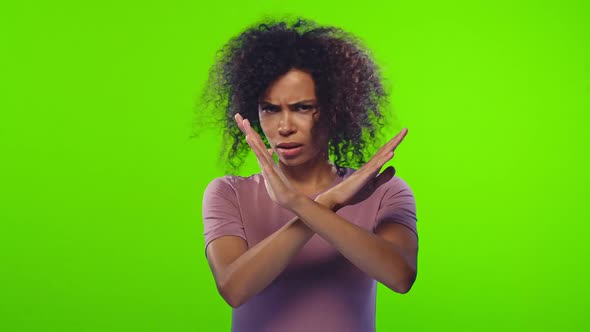 Annoyed Dark-skinned Woman Making Stop Gesture with Her Hands, Saying No alt