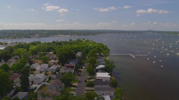 Flying Over a Suburban Neighborhood and Aerial View of Boats Anchored at Bay alt