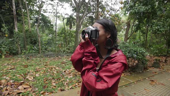 young girl takes photograph with old film camera alt