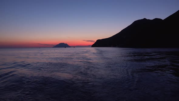 Lipari Islands in Mediterranean Sea, Horizon. Sailing Yachts and Boats in Distance. Colorful Sky alt