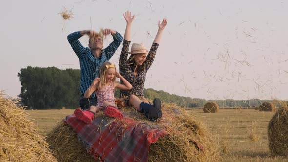 Young Family Having Fun on a Hay Bale alt