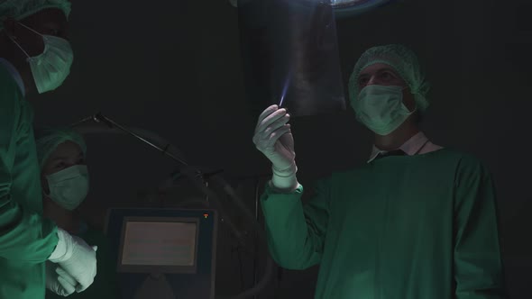 Surgeon team specialist meeting and discussion for treatment patient surgery while looking x-ray. alt