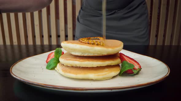 Chef Preparing Pancakes with Maple Syrup and Sugar Powder alt