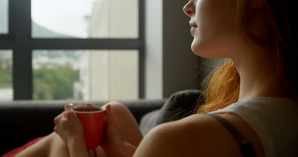 Woman having coffee in living room 4k alt