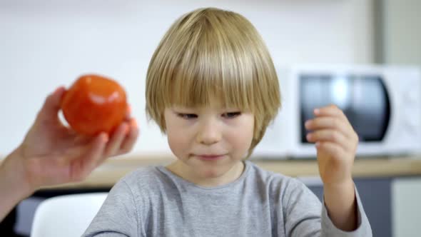 Closeup Portrait of Cute Blond Little Boy with Blue Eyes Having Breakfast in the Morning alt
