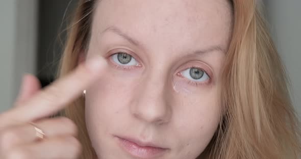 Woman applying eye primer. alt