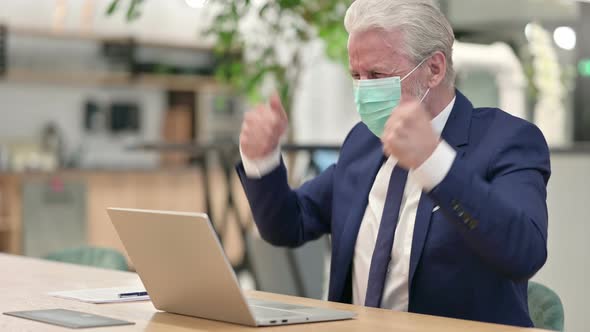 Senior Old Businessman with Face Mask Celebrating on Laptop  alt