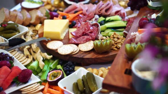 Table covered in abundant gourmet food banquet, close up slide left reveal alt