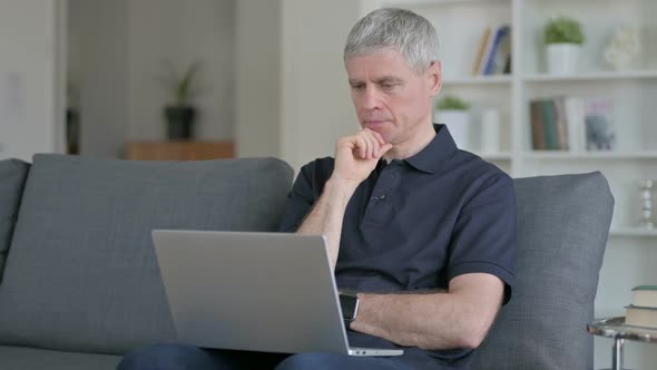 Professional Middle Aged Businessman Using Laptop on Sofa alt