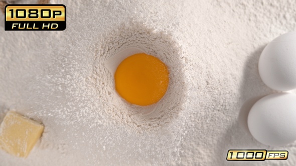 Raw Egg Yolk Falling into Flour alt