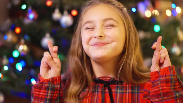 Headshot Portrait of Excited Charming Caucasian Girl Crossing Fingers Wishing Miracle on Christmas alt