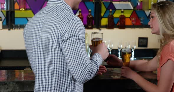 Couple interacting with each other while having beer alt