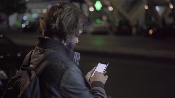 Caucasian Man Using Smartphone Near Road in Night City alt