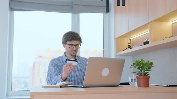 Man holds a credit card in his hand, online shopping in stores, pays taxes with a credit card online alt