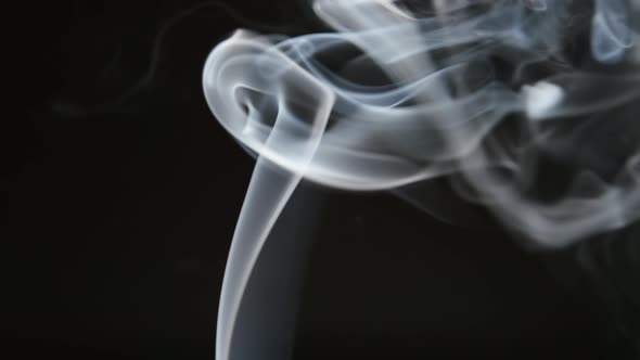 Smoke lifts and dispels on a black background