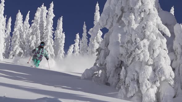 A man skiing down a snow-covered mountain in the winter alt