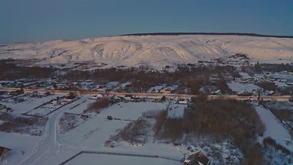 Russian Village in Winter Under a Bright Cloudy Sky