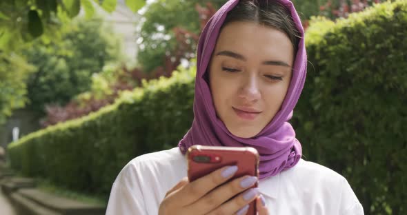 Beautiful Young Woman Looking at Smartphone, Wearing Traditional Headscarf. Attractive Female in alt
