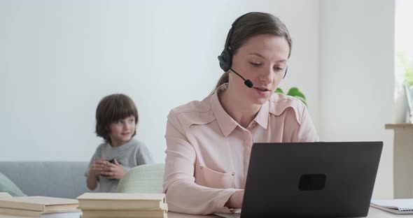 A Young Woman Businesswoman Participates in a Video Conference Communicating with Her Colleagues and alt