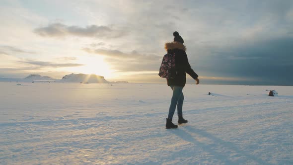 Yong Beautiful Woman Traveler Walking on Snow Desert in Iceland alt