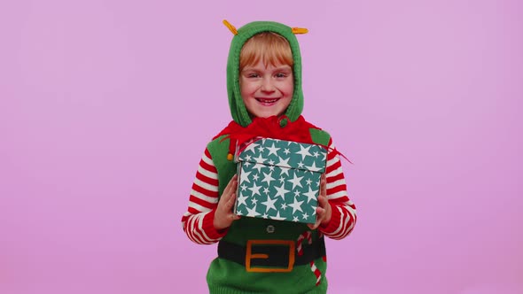 Cheerful Girl in Christmas Santa Costume Getting Present Gift Box Expressing Amazement Happiness alt
