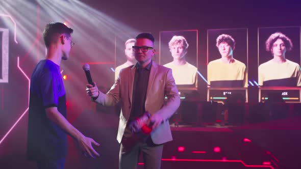 Young Cyber Sportsman and Adult Announcer Giving Motivational Speech alt