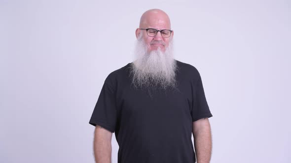 Sad Mature Bald Bearded Man Looking Upset and Giving Thumbs Down alt