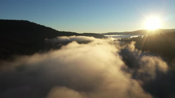 Aerial View of a Misty Lake. Dawn Dark Lights During Sunrise, Cold Weather. Flying Over Clouds alt
