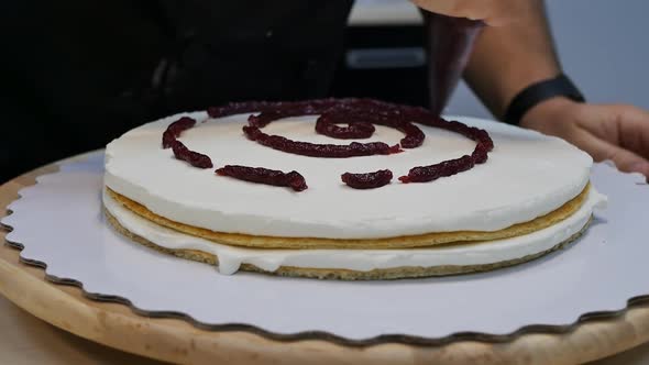 the Man's Hand of the Pastry Chef Squeezes the Jam Onto the Biscuit with Cream