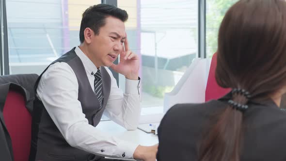 Asian unhappy young business man and woman group having a discussion brainstorming meeting in office alt