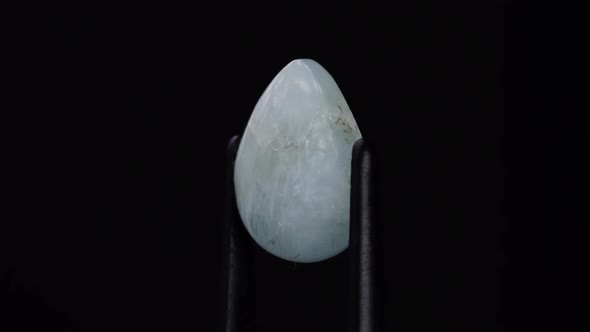 Natural Aquamarine in the Tweezers on the Background