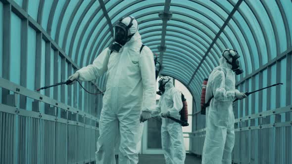 Cleaners in Hazmats Spray an Overpass To Kill Coronavirus. alt