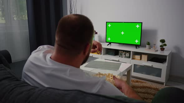 Man Watching Television with Green Screen Chroma Key alt