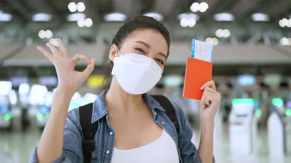 happiness smiling asian adult female wear face mask hand gesture showing passport