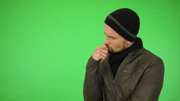 A Young Handsome Man in a Winter Outfit Thinks About Something - Green Screen Studio alt