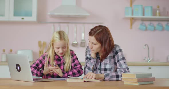 Family of 30s Mother and 10s Daughter Making Homework for Distance Schooling. Girl Writing with Pen