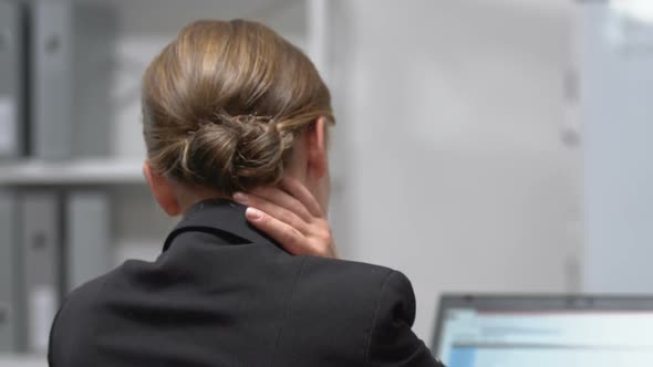 Female Employee Massaging Painful Neck, Sedentary Lifestyle Result, Back View