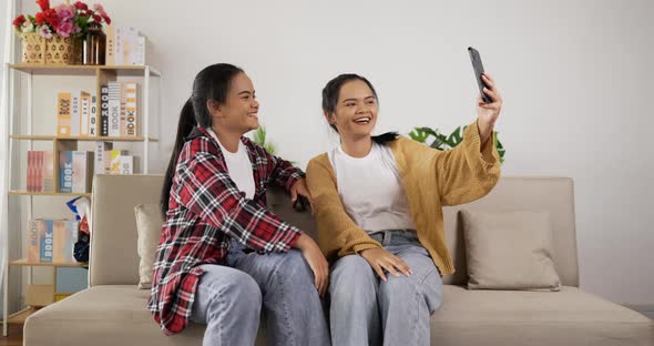Asian twin girls video call via smartphone alt