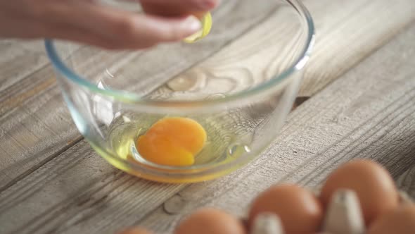 Woman Chef's Hands Break A Chicken Egg To Make Waffle Dough. Breaking The Egg Into A Transparent alt