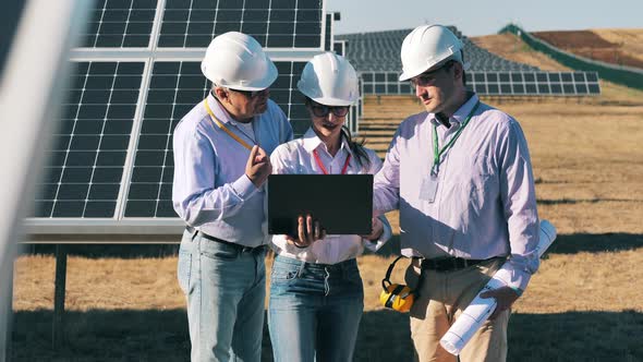 Safety Inspectors Are Talking Near Solar Panels Outdoors alt