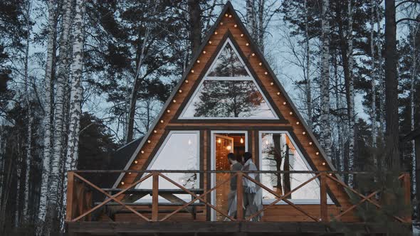 Couple Enjoying Scenery From Front Porch of Cabin alt