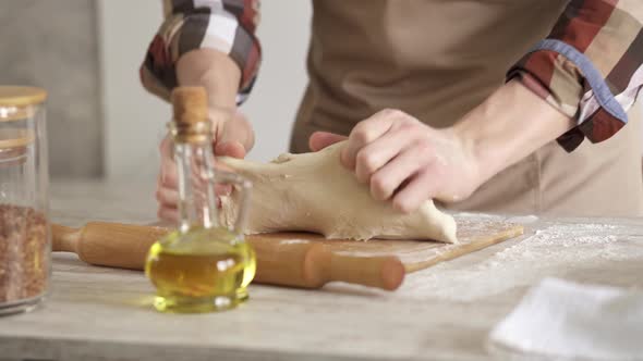 The Baker Is Diligently Kneading The Dough For Baking. alt