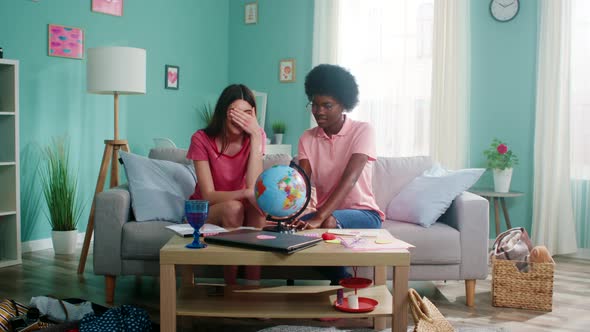 Two Women Friends Have Fun Playing with Globe