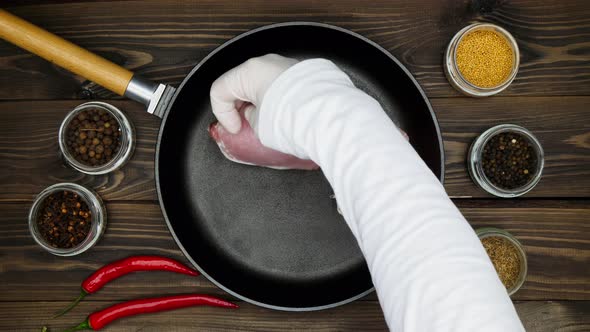 The cook puts the meat on the pan. Sliced pork steaks in a cast iron skillet. A metal frying pan