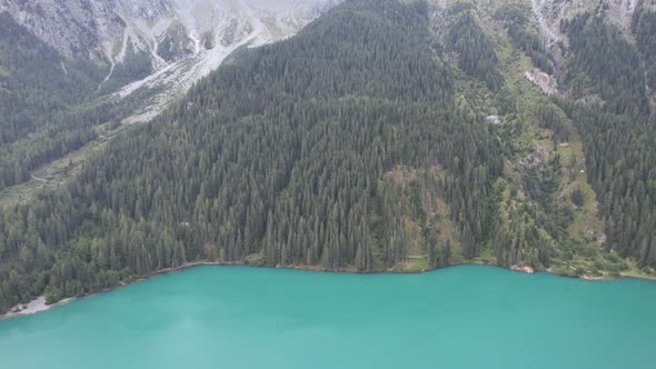 Aerial view of the green mountains forest and lake in Dolomites, Italy alt