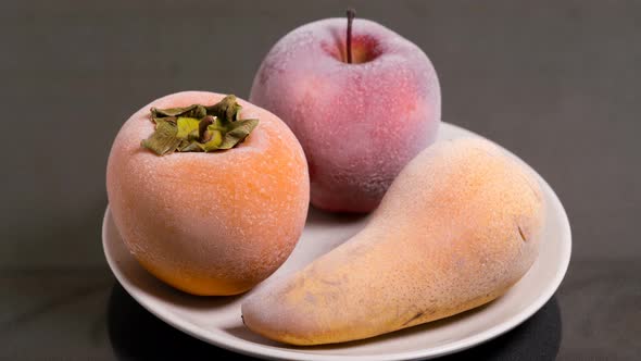 Defrosting Fruits, Persimmon Apple and Pear on a Plate