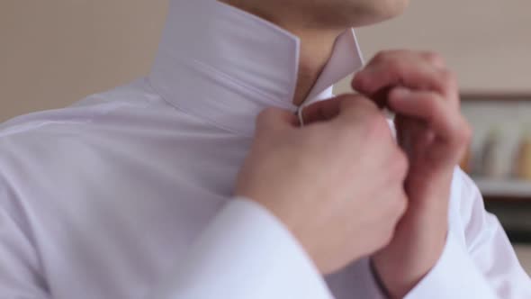 Closeup Man Buttoning His Shirt alt
