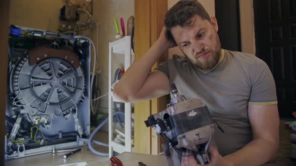 Middleaged Man Tired of Repairing His Home Washing Machine on His Own