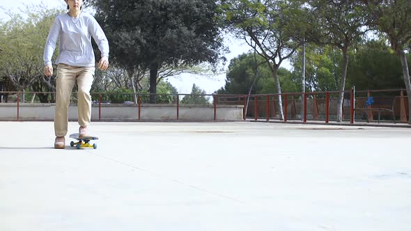 Teenage Girl Riding Skateboard in Empty Skatepark