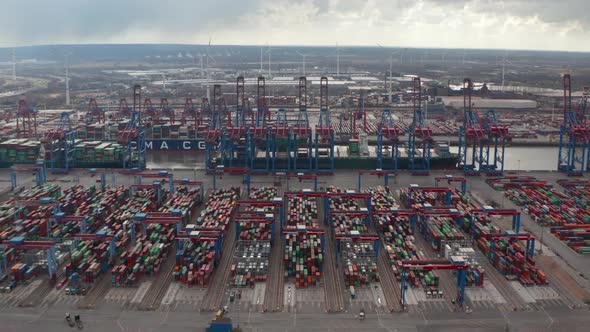 Aerial Dolly View of Colorful Containers and Large Cargo Cranes in Industrial Port in Hamburg alt